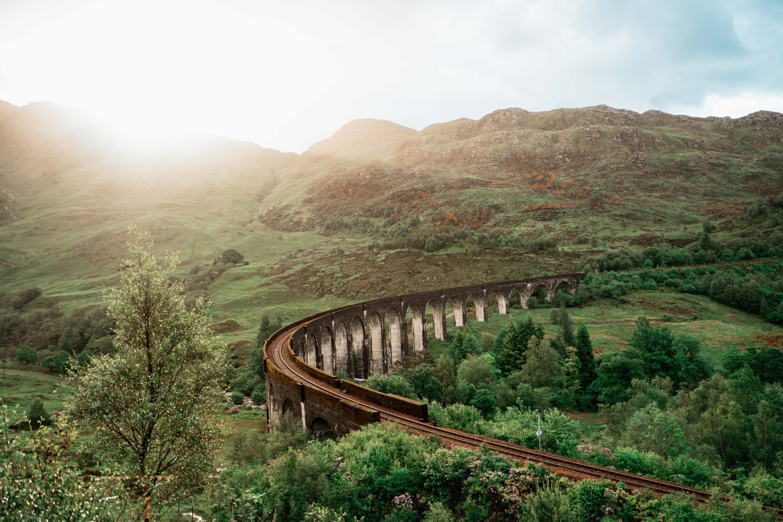 famous glenfinnan viaduct in scenic highlands of scotland on a sunny day