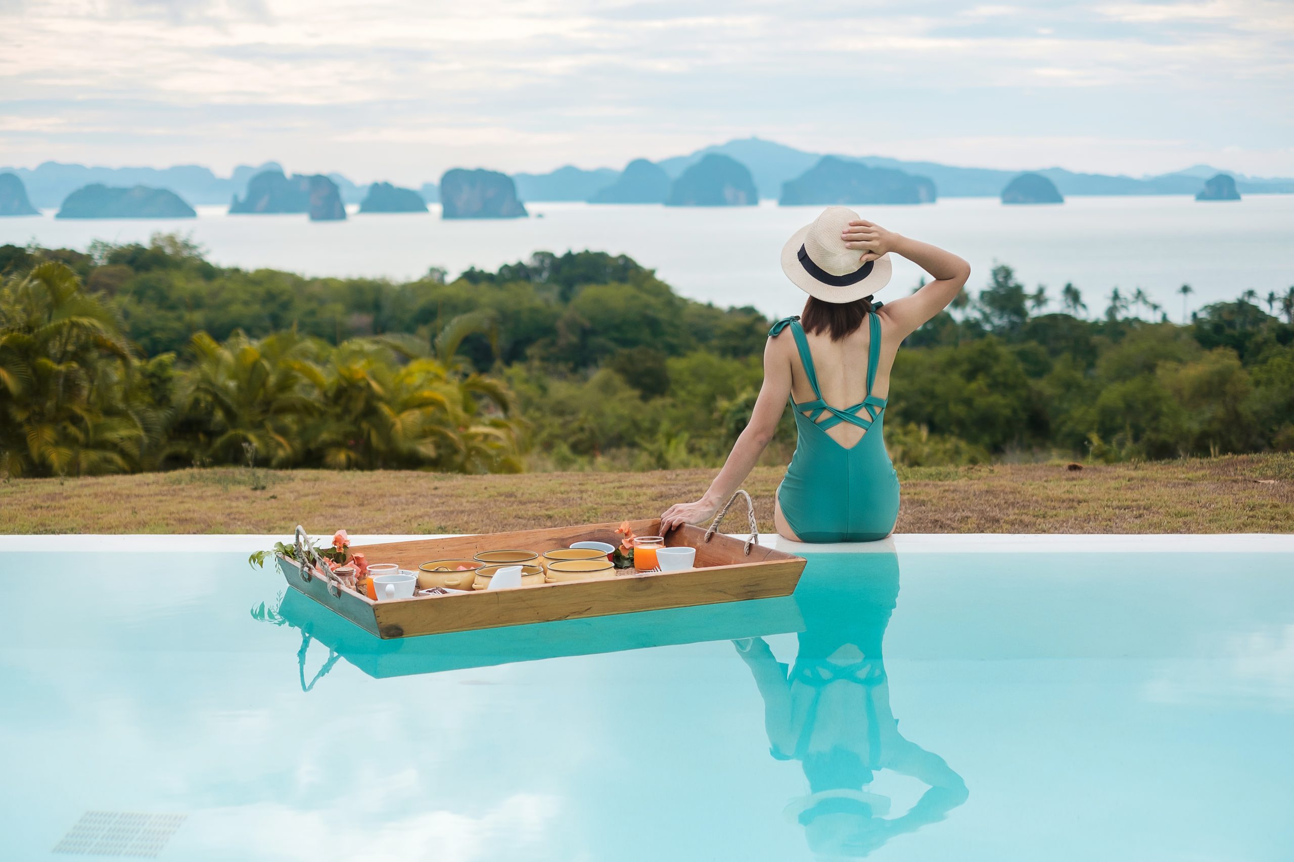 mujer desayunando en una piscina de lujo